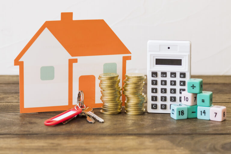 house-key-stacked-coins-calculator-math-blocks-wooden-table